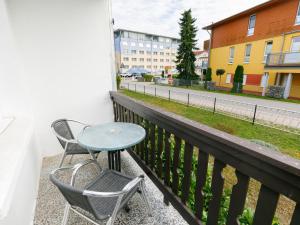 a table and chairs on a balcony with a street at Apartment Dünenhaus App- 104 by Interhome in Zempin