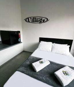 En eller flere senge i et værelse på Hotel Village