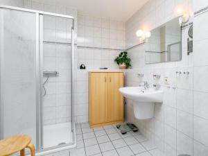 a white bathroom with a sink and a shower at Apartment Düneneck App-17 by Interhome in Zempin