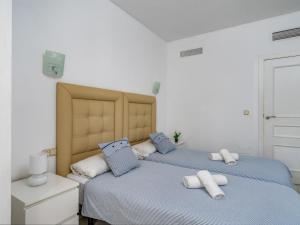 2 łóżka w białym pokoju z niebieskimi poduszkami w obiekcie Apartment Puerto Marina-2 by Interhome w mieście Benalmadena Costa