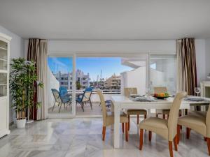 ein Esszimmer mit einem Tisch und Stühlen sowie einem Balkon in der Unterkunft Apartment Puerto Marina-2 by Interhome in Benalmadena Costa