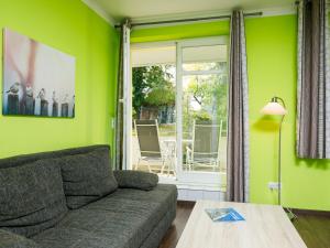 uma sala de estar com paredes verdes, um sofá e uma mesa em Apartment Dünenresidenz-9 by Interhome em Zinnowitz