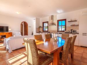 cocina y comedor con mesa de madera y sillas en Apartment Ana II - MUR115 by Interhome, en Cala Murada