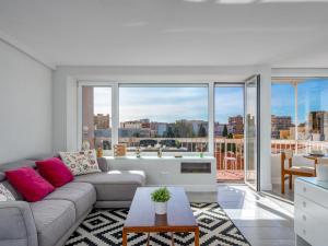 een woonkamer met een bank en een groot raam bij Apartment Eurosol-7 by Interhome in Torremolinos