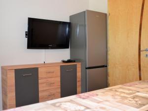 een slaapkamer met een tv en een dressoir met een koelkast bij Apartment Apart Garni Wachter - KPL646 by Interhome in Kappl