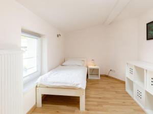 een witte slaapkamer met een bed en een raam bij Holiday Home Delphin by Interhome in Zinnowitz