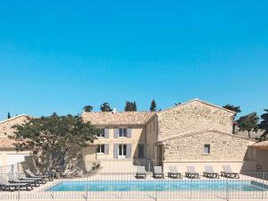 a large house with a swimming pool and chairs at Holiday Home La Machotte by Interhome in Valréas