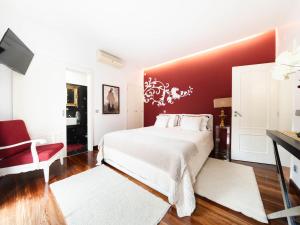 1 dormitorio con cama blanca y pared roja en Holiday Home D'Olivia - NZE220 by Interhome en Cela