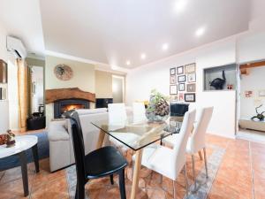 une salle à manger avec une table en verre et des chaises blanches dans l'établissement Holiday Home D'Olivia - NZE220 by Interhome, à Cela