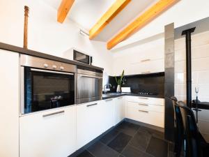 una cocina con armarios blancos y electrodomésticos negros en Holiday Home Conceição - NZE221 by Interhome, en Cela