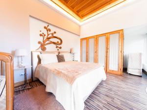 Cela的住宿－Holiday Home Conceição - NZE221 by Interhome，卧室设有白色的床和木制天花板。