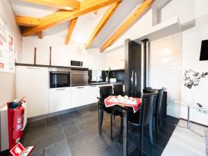 una cucina con armadi bianchi, sedie nere e tavolo di Holiday Home Conceição - NZE221 by Interhome a Cela