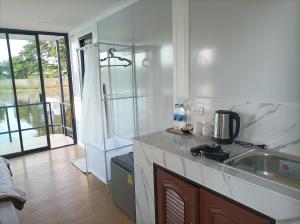 a kitchen with a sink and a counter top at ริมกว๊านชาเลย์ รีสอร์ทแอนด์คาเฟ่ Rimkwan Chalay Resort and Cafe in Ban Rong Ha
