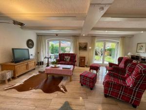 a living room with couches and a flat screen tv at Apartment Achentaler Vitalhotel by Interhome in Unterwössen