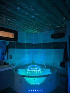 a blue bathroom with a tub with lights in it at Les Myrtilles, appartement au pied des pistes in Saint-Pierre-dels-Forcats