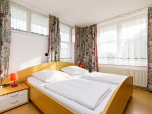 ein Schlafzimmer mit einem Bett in einem Zimmer mit Fenstern in der Unterkunft Apartment Dünenresidenz 24 by Interhome in Zinnowitz