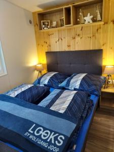 Bett in einem Zimmer mit einer Holzwand in der Unterkunft Holiday Home Alex by Interhome in Wemding