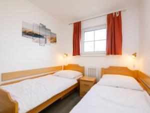 two beds in a small room with a window at Holiday Home Im Kiefernweg DHH 21 by Interhome in Zinnowitz