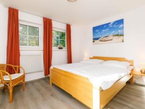 a bedroom with a bed and a desk and windows at Holiday Home Im Kiefernweg DHH 21 by Interhome in Zinnowitz