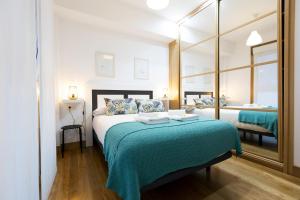1 dormitorio con 1 cama grande con manta verde en ARROLA by Smiling Rentals, en Hondarribia