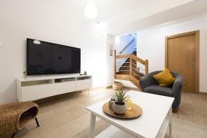 sala de estar con TV de pantalla plana en la pared en ARROLA by Smiling Rentals, en Hondarribia