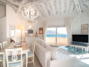 a dining room and living room with a table and a television at Apartment Camilla by Interhome in Casa Tamponi