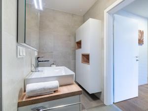 a bathroom with a white sink and a mirror at Apartment Seensucht alpe maritima Ski & See-Top 25 by Interhome in Annenheim +21 photos