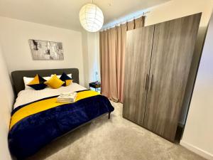um quarto com uma cama grande com amarelo e azul em 3Bedroom, 2Bathroom, Balcony,Luxury Flat Westfield em Londres