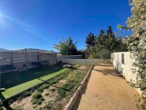 a backyard with a retaining wall and a lawn at Maison plain pied au calme in Cuges-les-Pins
