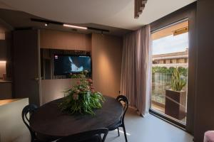 a dining room with a table with flowers on it at Dimora San Girolamo Luxury Apartments e Rooms in Marsala