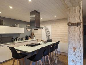a kitchen with a table with chairs and a stove at Les Myrtilles, appartement au pied des pistes in Saint-Pierre-dels-Forcats