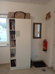a white book shelf with a bag on top of it at Ferienzimmer Waldzauber in Borkwalde