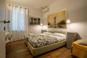 ローマにあるFotofever Apt, two bedrooms with air conditioned in elegant shopping area, close to Vatican Cityのベッドルーム1室(ベッド1台付)が備わります。壁には絵画が飾られています。