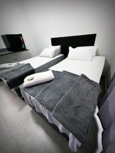 two beds sitting next to each other in a room at Hotel Village in São Bernardo do Campo
