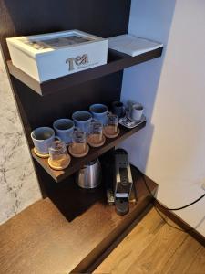 a shelf with cups and a box and a phone at Noma Kopaonik in Kopaonik