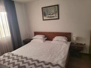 a bedroom with a bed with white sheets and pillows at Noma Kopaonik in Kopaonik