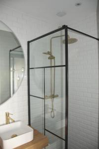 La salle de bains est pourvue d'une douche en verre et d'un lavabo. dans l'établissement Apt 6 personnes terrasse vue parc, à Dunkerque