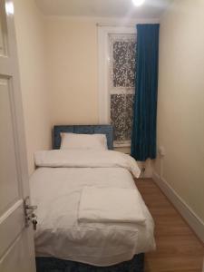 een kleine slaapkamer met een bed en een raam bij Nice Single Room near London Seven Kings Train station in Londen