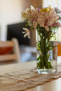 un jarrón lleno de flores sentado en una mesa en Céntrico Departamento Tangerine San Rafael en San Rafael
