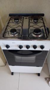 a white stove top oven sitting in a kitchen at CASA DE TEMPORADA RECANTO FELIz 2 in Aracaju