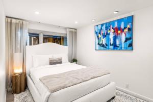 a bedroom with a white bed and a painting on the wall at Snowmass Villas 3 plus loft in Snowmass Village