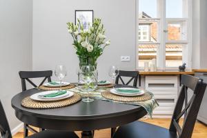 uma mesa de jantar preta com um vaso de flores em Rent like home - Plac Zamkowy 1/13 em Varsóvia
