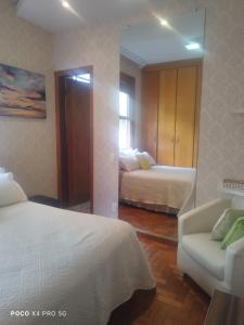 1 dormitorio con 2 camas, sofá y espejo en Quarto Suite - SAVASSI BH, en Belo Horizonte