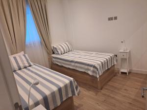 Duas camas num pequeno quarto com uma janela em Main Street - 3 Bed Room - Family Friendly em Gibraltar