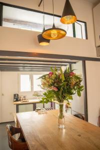 wazon kwiatów siedzący na drewnianym stole w obiekcie L'Agora Home HH - Centre Historique Corum - Netflix & Prime Video w Montpellier