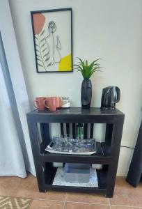 a black shelf with glasses and a plant on it at Ilnika Farm Stay in Naboomspruit