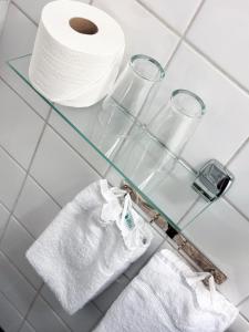 uma prateleira de vidro com um rolo de papel higiénico em Quality Hotel Galaxen em Borlänge