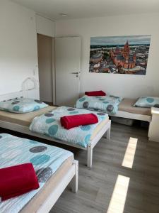 Habitación con 3 camas y una pintura en la pared. en Apartment in Mainz-Lerchenberg, en Mainz