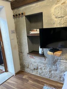 a flat screen tv on a stone wall at Elena Rooms Split in Split