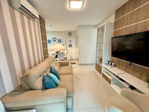 ein Wohnzimmer mit Couch und Flachbildfernseher in der Unterkunft Costa do Marfim - Bombinhas in Bombinhas